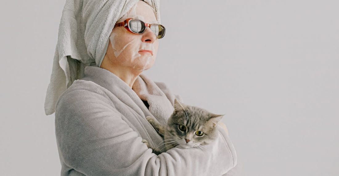 Senior Pet - Woman after bath standing with cat in arms